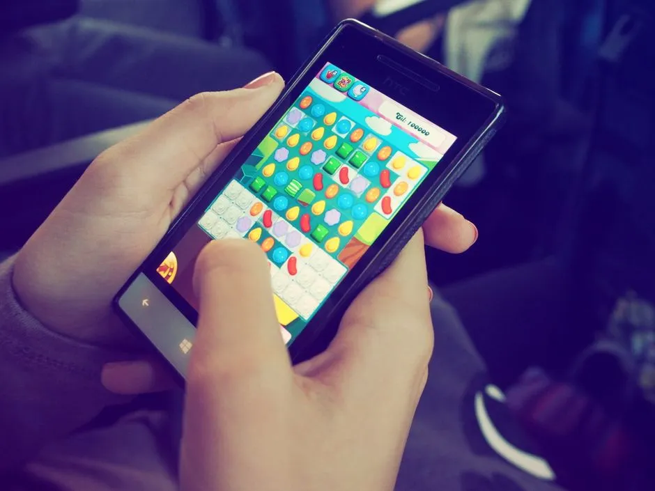 A person playing a match-style puzzle game on a smartphone